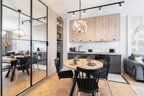 a kitchen and living room with tables and chairs at Perfect Stay - "Apartament Cosmo" - free parking in Toruń