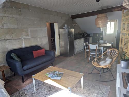 a living room with a couch and a table at Appartement des hirondelles , au pied du château in Chinon