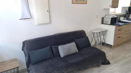 a living room with a couch and a kitchen at Chez Martin - centre-ville in Brassac-les-Mines