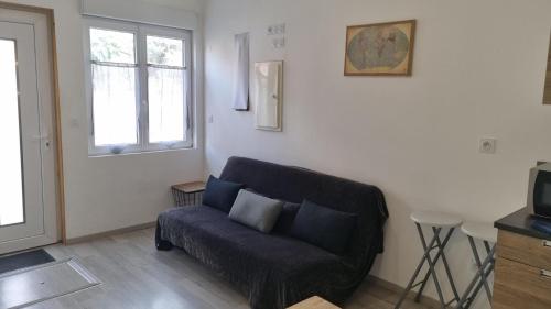 a living room with a couch and a window at Chez Martin - centre-ville in Brassac-les-Mines