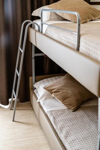 a ladder on a bunk bed with pillows on it at Hotel Bellavista in Marina di Varcaturo