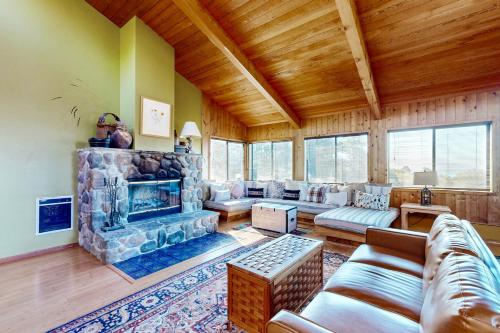 a living room with a stone fireplace in a house at Sea View in Sea Ranch