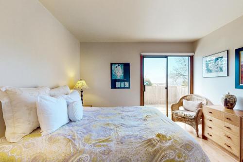 a bedroom with a bed and a chair and a window at Sea View in Sea Ranch