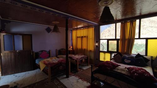 a room with two beds and windows and a couch at Guesthouse Panorama Todra in Tinerhir