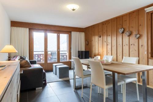 a dining room with a table and chairs and a couch at La Ruinette-one-bed Apartment Near Medran in Verbier
