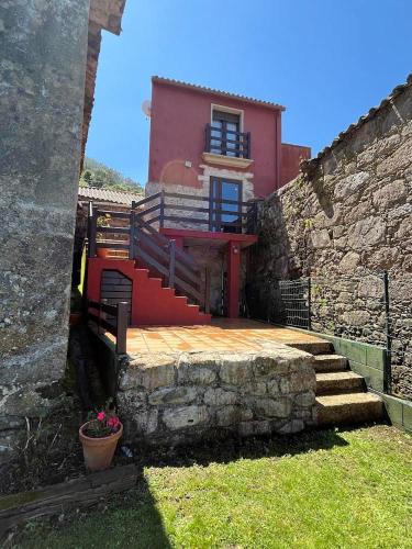 a house with a staircase in front of a wall at Casa Dantes in Oia