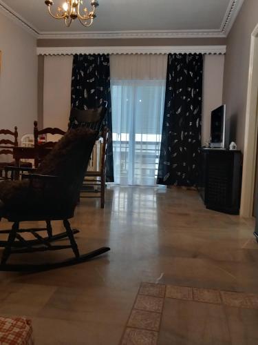 a living room with a rocking chair and a table at FLAT with Private Rooms in Agrinion