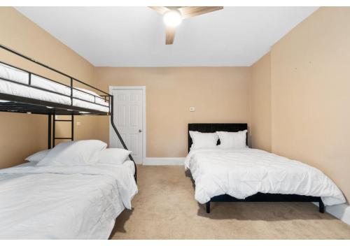 a bedroom with two beds and a ceiling fan at Epic Spa & Play Retreat NYC EWR Sleeps 30! in Bayonne