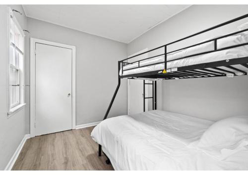 a bedroom with a bunk bed with white sheets at Epic Spa & Play Retreat NYC EWR Sleeps 30! in Bayonne