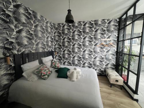 - une chambre avec un lit blanc et du papier peint noir et blanc dans l'établissement Appartement hôtel de ville INDUS, à Vannes