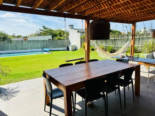 un tavolo e sedie in legno su un patio con amaca di Casa de Piedra a Maldonado