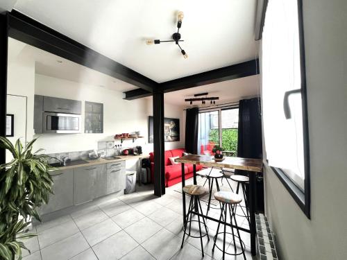 - une cuisine et un salon avec une table et des tabourets dans l'établissement Appartement hôtel de ville INDUS, à Vannes