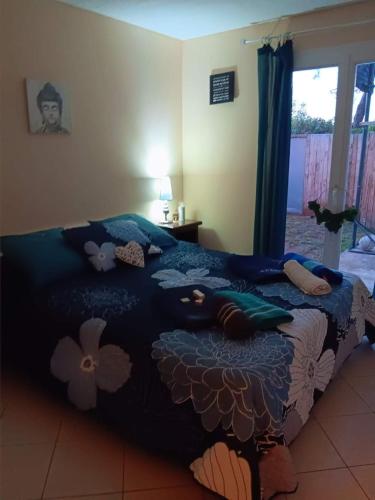 - un lit avec une couette bleue et des fleurs dans l'établissement Paradis terrestre sud de la France, avec sa piscine bali privée, clim, jardin, animaux admis,5 mn autoroute, à Toulouges