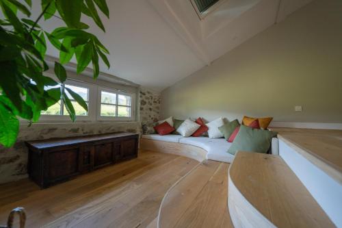 a living room with a white couch and a window at Belle grange en bord de rivière in Serres-sur-Arget