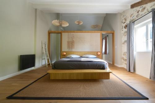 a bedroom with a bed with a wooden headboard at Belle grange en bord de rivière in Serres-sur-Arget