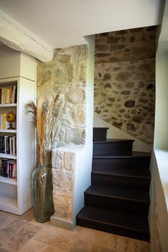 a staircase in a home with a stone wall at Belle grange en bord de rivière in Serres-sur-Arget
