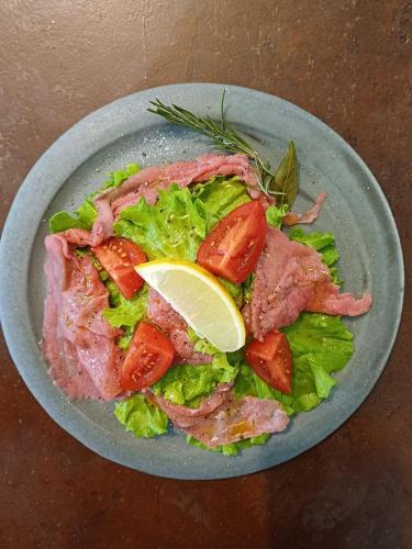 a plate of salad with meat and lettuce and tomatoes at B&B VillaDansio in Rezzoaglio