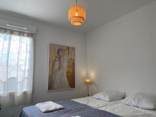 une chambre avec deux lits et un tableau au mur dans l'établissement Villa avec piscine / 6 personnes, à Saint-Ambroix