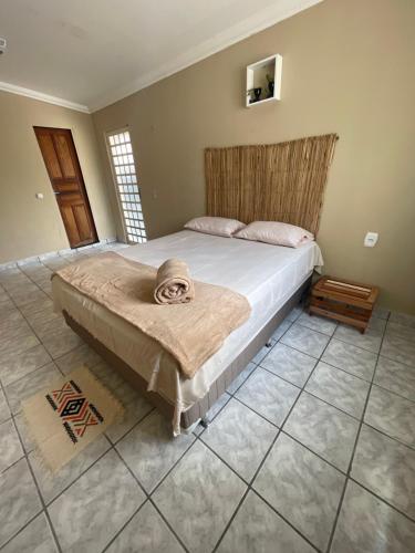 a bedroom with a bed with a blanket on it at Hostel Wei in Boa Vista