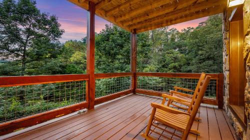 a porch with two wooden chairs on top of it at Applewood in Pigeon Forge