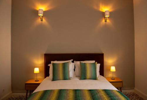 a bedroom with a bed with two lights on the wall at Appartements Balima Résidences Sidem in Rabat