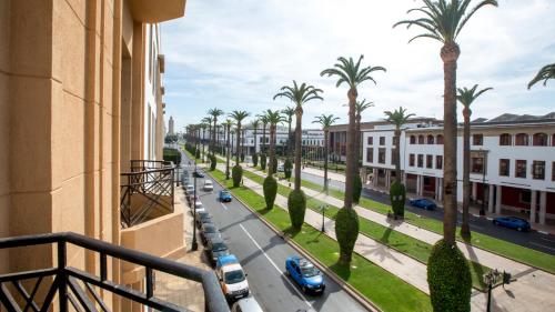 a view of a street with palm trees from a balcony at Appartements Balima Résidences Sidem in Rabat