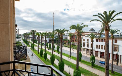 a view of a street with palm trees and buildings at Appartements Balima Résidences Sidem in Rabat
