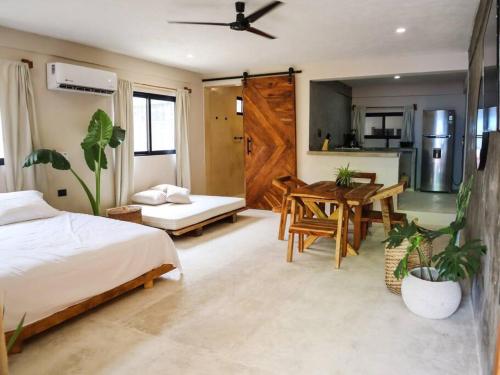 a bedroom with a bed and a table and a kitchen at Cozy Tropical Suite for 1-4 Pp in Isla Mujeres in Isla Mujeres