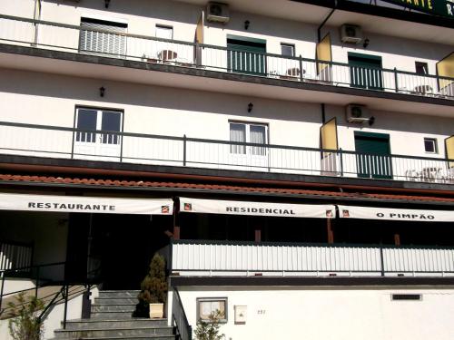 ジェレスにあるO Pimpaoのバルコニー付きの建物で、正面に階段があります。