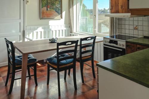 a kitchen with a wooden table and chairs and a stove at Det huset på landet in Nøtterøy