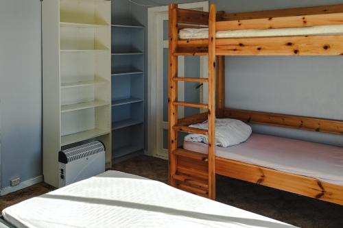 a bedroom with a bunk bed with a ladder and a bunk bed gmaxwell gmaxwell gmaxwell at Det huset på landet in Nøtterøy