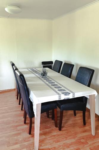 a dining room table with black chairs around it at Det huset på landet in Nøtterøy