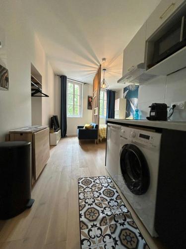 - une cuisine avec un lave-linge au milieu d'une pièce dans l'établissement Blue Forest - T1 Hyper centre - Paisible, à Toulouse