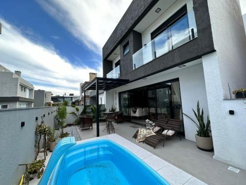 a house with a swimming pool in front of it at Residência Exclusiva no Condomínio Blue, Xangri-Lá in Xangri-lá