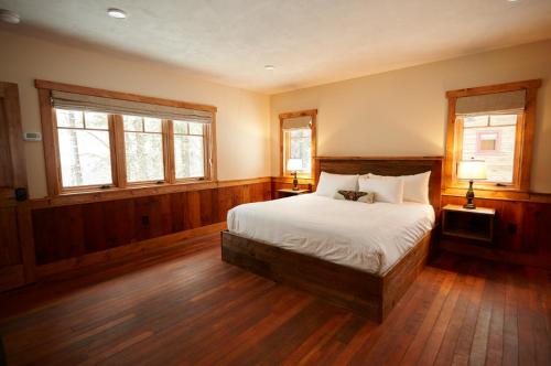 a bedroom with a bed and two windows at Seesaw's Lodge in Peru