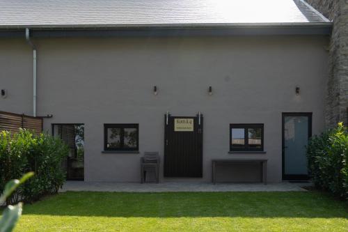 a white house with a door with a sign on it at Kom à 4 in Vielsalm