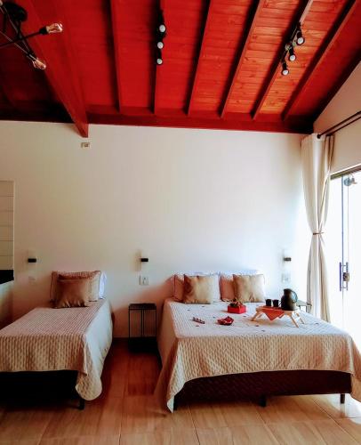 a bedroom with two beds and a red ceiling at Cabanas Privativas com Jacuzzi, Cozinha, Churrasqueira e Decoração - Sitio Pauletto in Jarinu