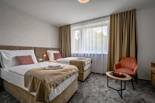 a hotel room with two beds and a chair at PENZIÓN u JAKUBA & REŠTAURÁCIA Bezplatné Parkovanie in Martin