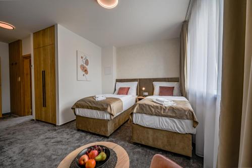 a hotel room with two beds and a bowl of fruit on a table at PENZIÓN u JAKUBA & REŠTAURÁCIA Bezplatné Parkovanie in Martin
