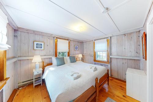 een slaapkamer met een bed in een kamer met houten wanden bij Old Wharf Escape in Dennis Port