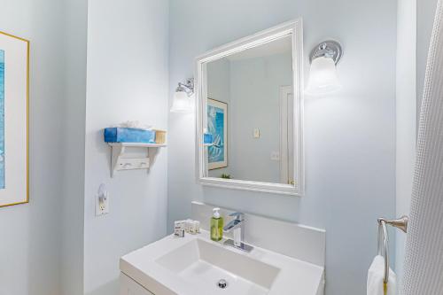 een witte badkamer met een wastafel en een spiegel bij Old Wharf Escape in Dennis Port