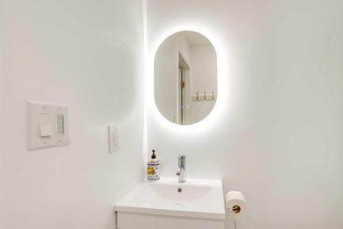 a white bathroom with a sink and a mirror at Front Royal Retreat on 3 Acres with Mtn Views! in Front Royal