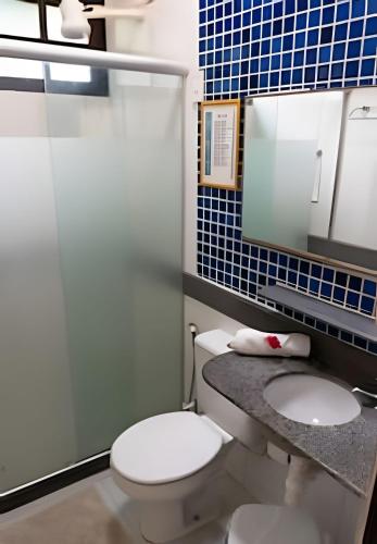 a bathroom with a toilet and a sink and a mirror at Prive de Veraneio in Porto De Galinhas