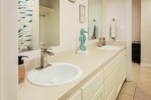 a bathroom with two sinks and two mirrors at 8 Mins to SPI Beach Spacious 3BR with Backyard in Port Isabel