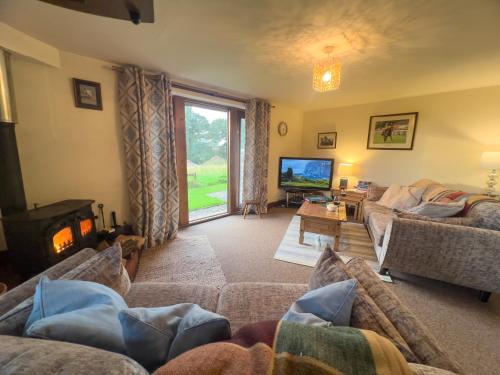 a living room with a couch and a tv at Tarnside Cottages in Brampton
