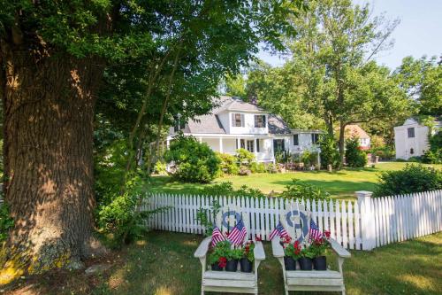a white fence with a bench with american flags on it at Shopping Restaurants 6 mins to Beach AC in Yarmouth