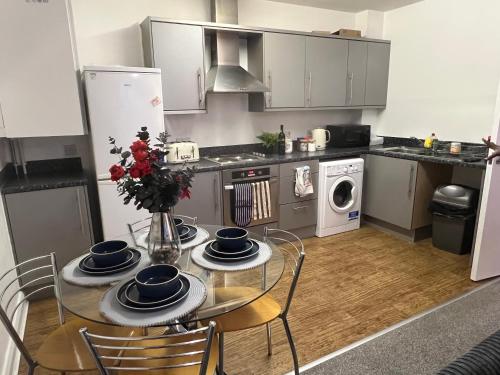 a kitchen with a table and chairs and a kitchen with a refrigerator at Flat in Greater Manchester in Manchester