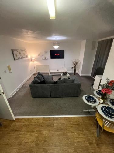 a living room with a couch and a flat screen tv at Flat in Greater Manchester in Manchester