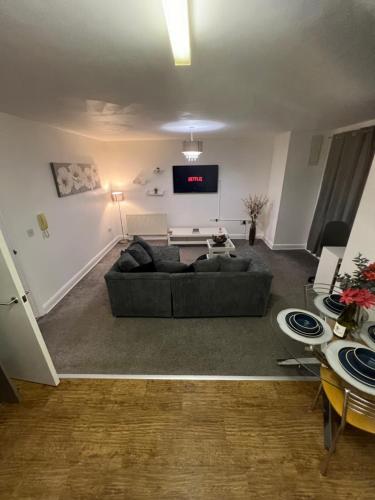 a living room with a couch and a flat screen tv at Flat in Greater Manchester in Manchester