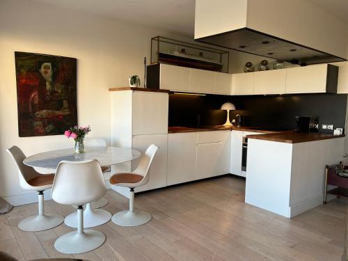 une cuisine avec une table et des chaises dans une pièce dans l'établissement T3 vue port 200m de la plage 2 chambres avec garage, à Carnon-Plage